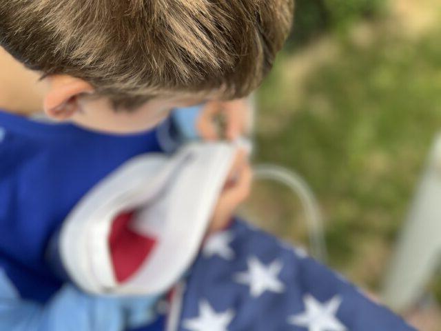 Student putting up flag on flag pole